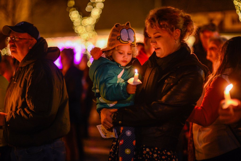 Mother and child hold a candle at Light Up the Night in Downtown Brevard to celebrate the holiday season