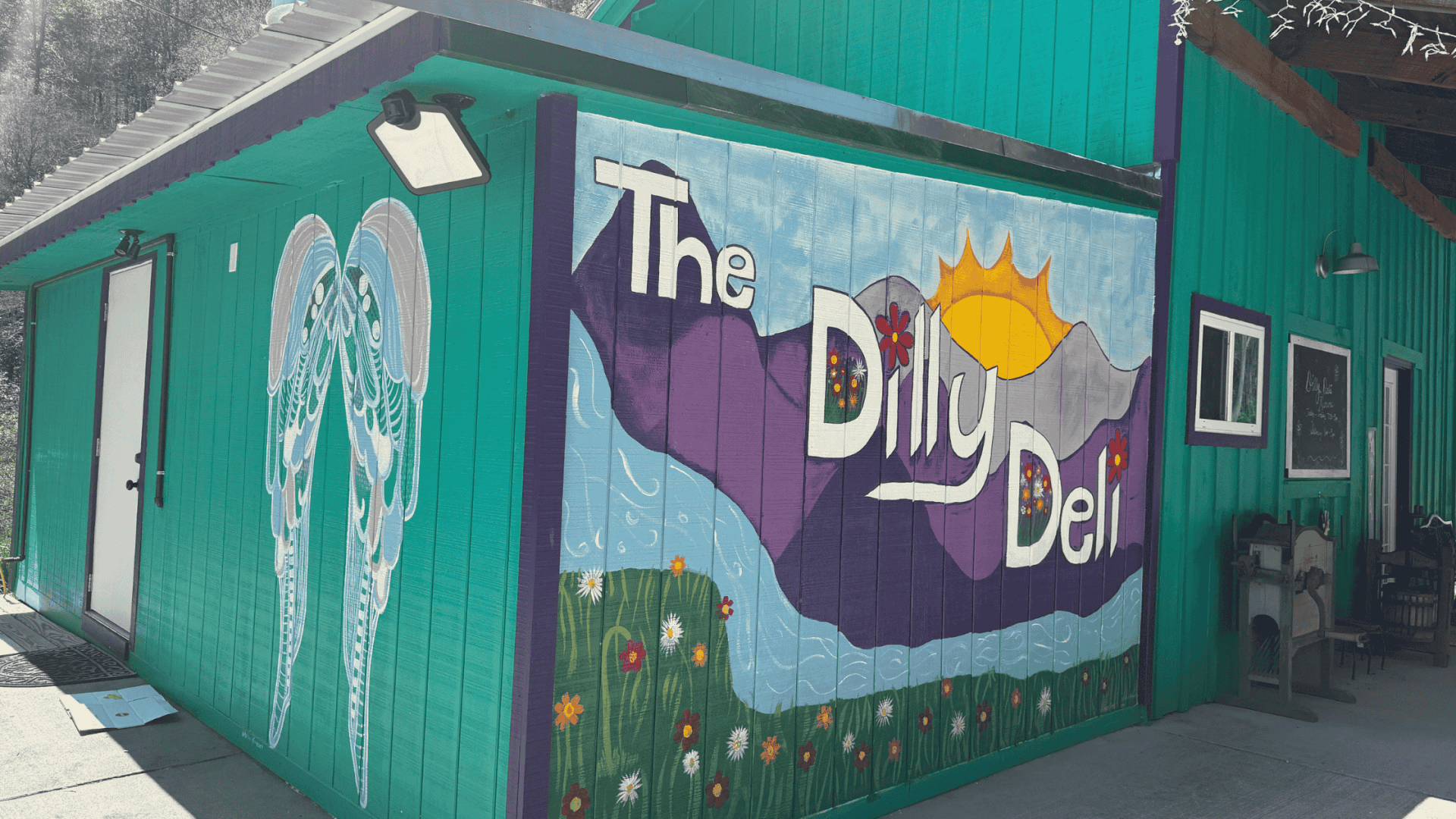 The Dilly Deli in Rosman, featuring a mural of mountains and the French Broad River