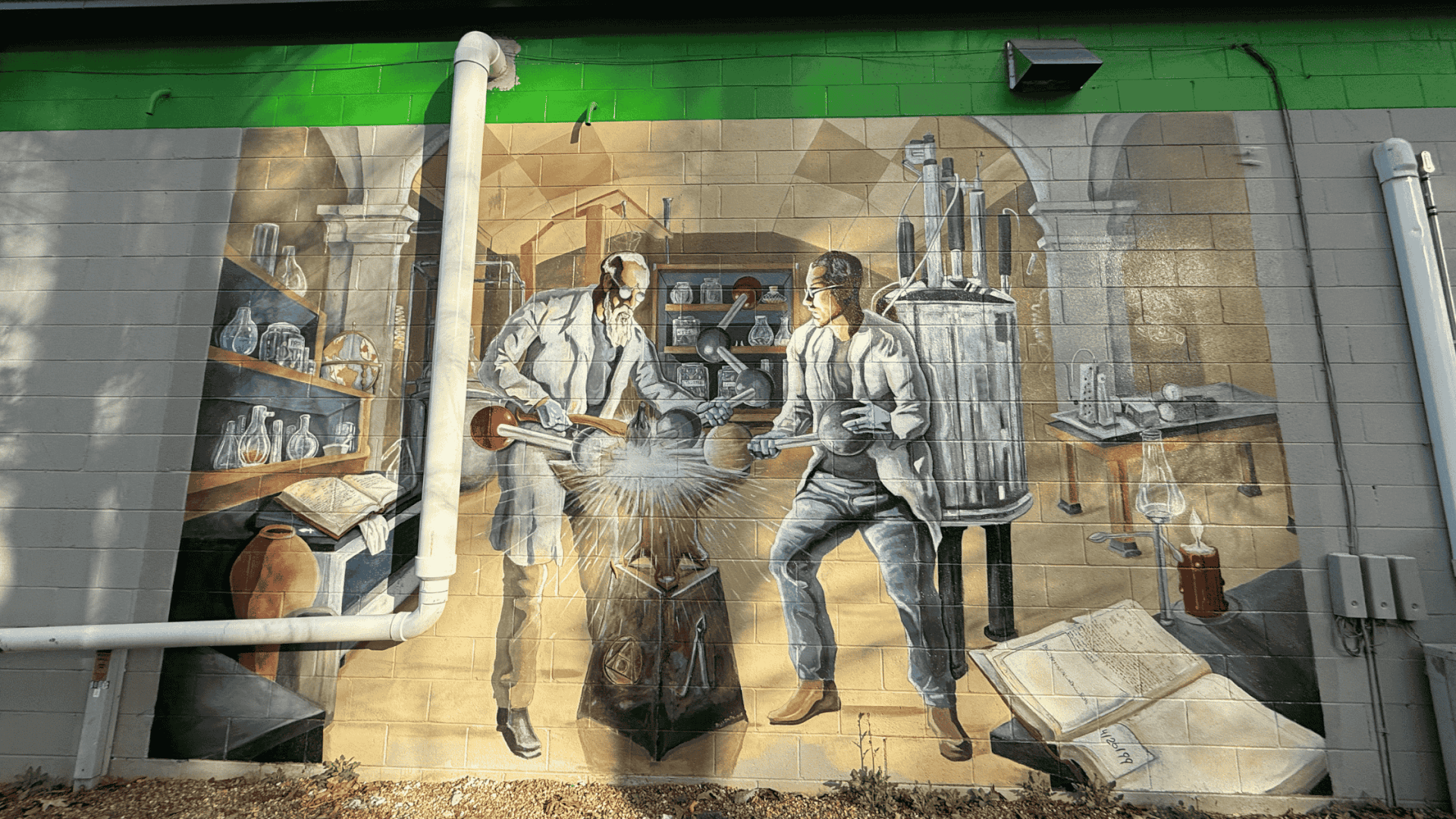 Estatoe Trail mural featuring two guys bonding an atom, near Downtown Brevard.